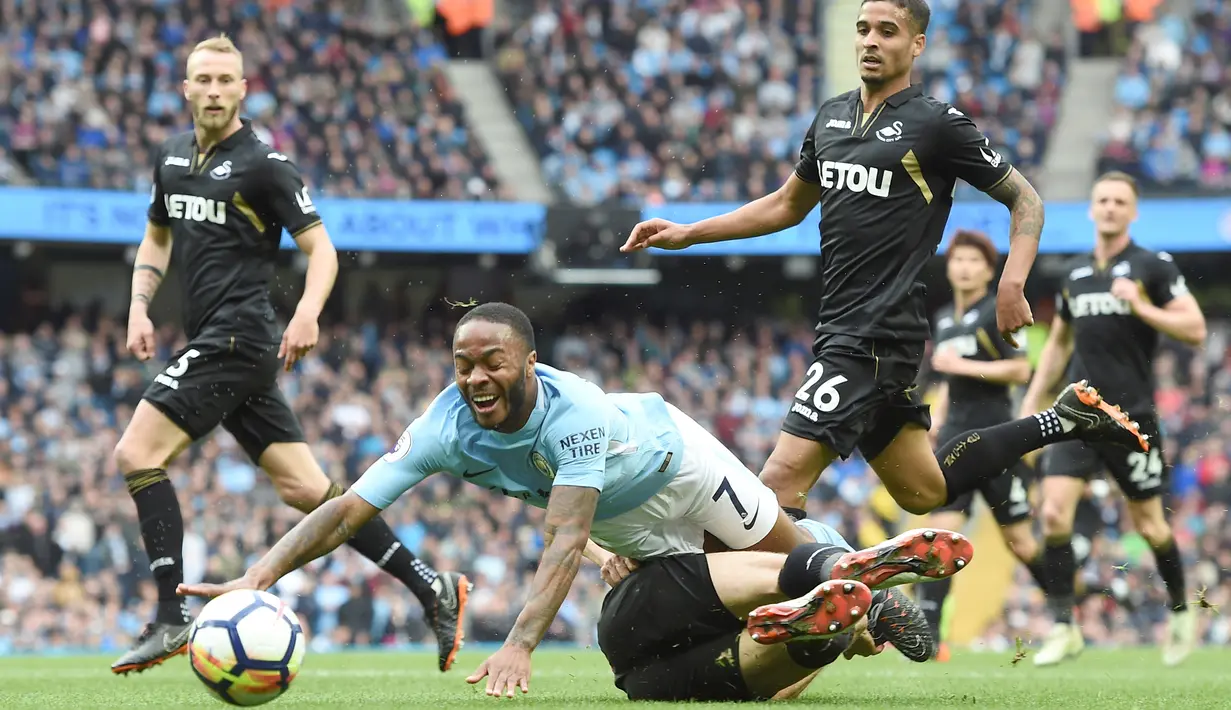 Pemain Manchester City, Raheem Sterling (kiri) jatuh saat berebut bola dengan pemain Swansea City, Federico Fernandez pada lanjutan Premier League di Etihad Stadium, Manchester, (22/4/2018). Manchester City menang 5-1. (AFP/Paul Ellis)