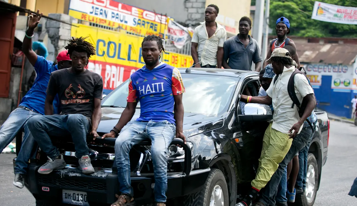 Pengunjuk rasa mengendarai mobil saat protes krisis bahan bakar di Port-au-Prince, Haiti, Senin (16/9/2019). Krisis bahan bakar menyebabkan transportasi umum tidak beroperasi. (AP Photo/Dieu Nalio Chery)
