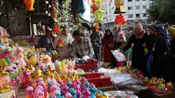 Para calon pembeli memilih lentera Ramadan yang dijajakan salah satu kios di pasar Kota Gaza, Kamis (25/5). Warga Palestina merayakan datangnya bulan puasa dengan memasang lentera tradisional khas Ramadan sebagai dekorasi rumah. (AP Photo/Adel Hana)