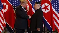 Presiden AS Donald Trump menjabat tangan pemimpin Korea Utara Kim Jong-un dalam sesi makan malam, Rabu 27 Februari 2019, di Hanoi, Vietnam. (AP / Evan Vucci)