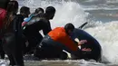 Tim penyelamat dan sukarelawan berupaya mengembalikan paus pembunuh ke laut setelah terdampar, di pantai Mar Chiquita, Argentina, Senin (16/9/2019). Sebanyak enam dari tujuh paus pembunuh yang ditemukan terdampar berhasil dikembalikan ke laut, tetapi satu di antara mereka mati. (AP/Marina Devo)