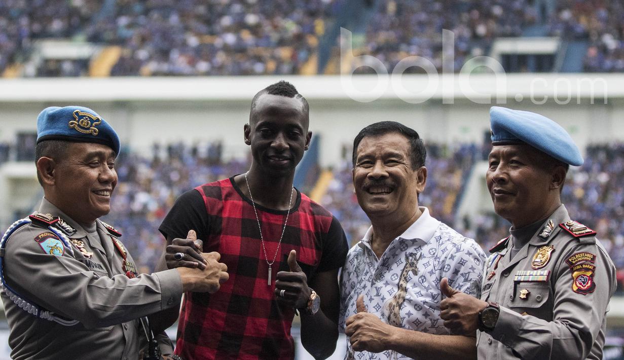 Dua orang polisi mengajak foto bersama manajer Persib Bandung, Umuh Muchtar dan Makan Konate. Kehadiran pemain yang membawa Persib juara ISL 2014 itu tentu memberikan kegembiraan bagi Bobotoh. (Bola.com/Vitalis Yogi Trisna)
