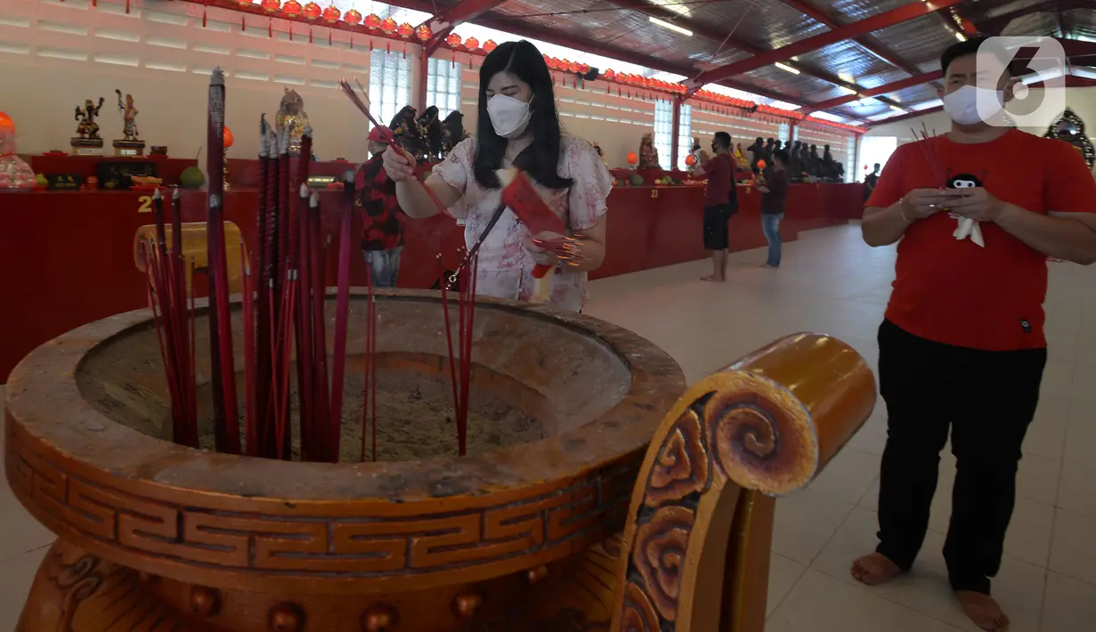 Warga keturunan Tionghoa melakukan sembahyang saat perayaan Tahun Baru Imlek 2572 di Vihara Dharma Bhakti, Glodok, Jakarta, Jumat (12/2/2021). Perayaan Imlek tahun ini, pengurus vihara melakukan pembatasan pengunjung dan tetap mengikuti protokol kesehatan COVID-19. (merdeka.com/Imam Buhori)