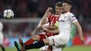 Pemain Bayern, Thomas Mueller (kiri) berebut bola dengan pemain Sevilla, Clement Lenglet pada leg kedua perempat final Liga Champions di Allianz Arena stadium, Munich, (11/4/2018). Bayern lolos ke semifinal dengan agregat 2-1. (AP/Matthias Schrader)