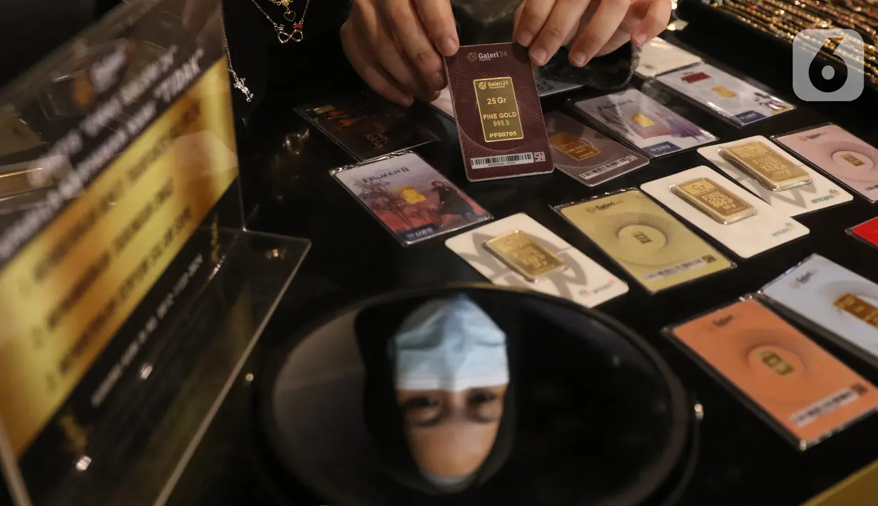Karyawan memperlihatkan kepingan emas yang dijual di Galeri 24, Jakarta, Selasa (15/12/2020). Harga emas hasil produksi PT Aneka Tambang Tbk (Antam) atau emas Antam kini turun Rp 1.000 per gram menjadi Rp 951 per gram pada perdagangan, Selasa (15/12). (Liputan6.com/Angga Yuniar)