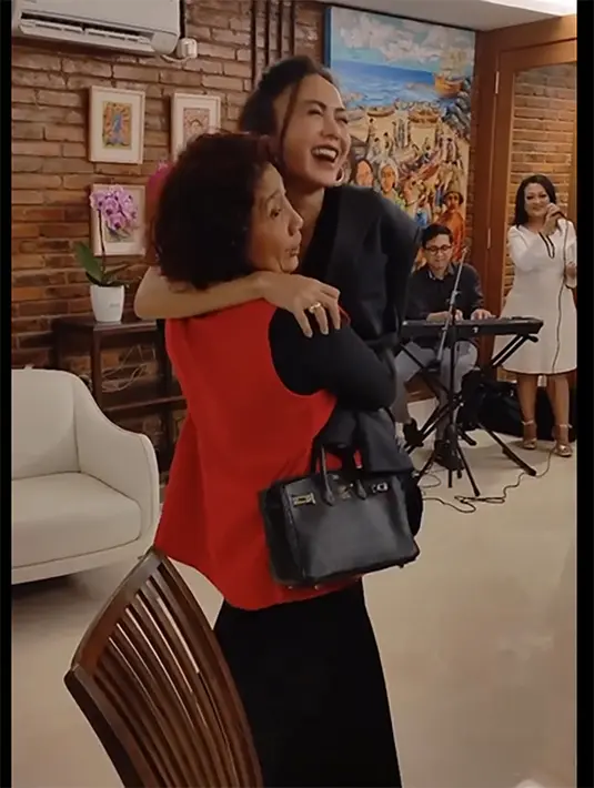 Sebelum duduk, Susi Pudjiastuti kembali mengangkat tubuh Yuni Shara. Perempuan dua orang anak itu tampak  tertawa sambil memegang pundak Susi. [Instagram/susipudjiastuti115]