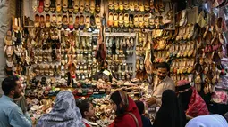 Suasana terlihat sibuk dan meriah dipadati warga yang akan membeli pakaian, sepatu, dan kebutuhan dekorasi Hari Raya Idul Fitri. Tampak dalam foto, Umat Muslim Pakistan berbelanja untuk perayaan Idul Fitri, selama minggu terakhir bulan suci Ramadan 1447 Hijriah, di Rawalpindi pada 14 Maret 2026. (Farooq NAEEM/AFP)