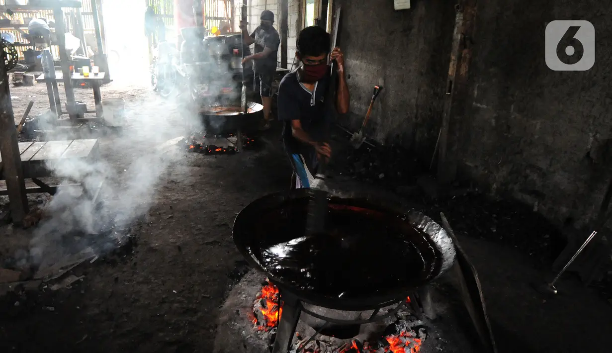 Pekerja menyelesaikan pembuatan dodol Betawi di kawasan Cilenggang, Serpong, Tangerang Selatan, Banten, Rabu (28/4/2021). Jumlah produksi Betawi pada tahun ini bisa mencapai 120 kilogram per hari dengan dengan harga jual Rp 52 ribu per kilogram. (merdeka.com/Arie Basuki)