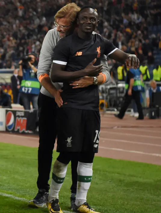 Pelatih Liverpool Jurgen Klopp memeluk Sadio Mane usai pertandingan semifinal Liga Champions di Stadion Olimpiade, Roma (2/5). Liverpool takluk 4-2 atas Roma di leg kedua  dan melaju ke final usai menang agregat 7-6. (AFP Photo/Paul Ellis)