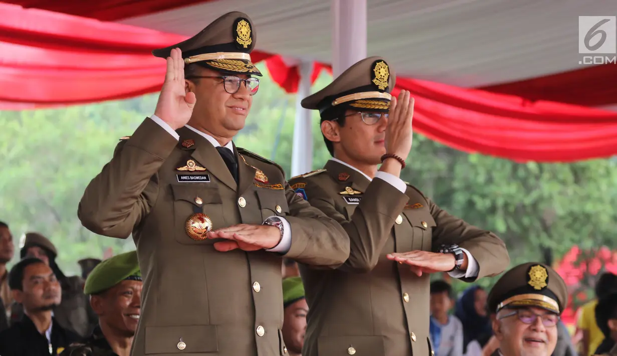 Gubernur DKI Anies Baswedan didampingi Wakil Gubernur, Sandiaga Uno menghadiri upacara peringatan HUT Satpol PP ke-68 di Monas, Jakarta, Kamis (26/4). Dalam acara HUT Satpol PP, Anies-Sandi juga berkesempatan memotong tumpeng. (Liputan6.com/Arya Manggala)