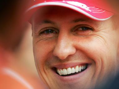 Pembalap Ferrari, Michael Schumacher tersenyum di paddock setelah sesi kualifikasi Formula 1 GP Bahrain di Sirkuit Sakhir pada 11 Maret 2006. (AFP/Loic Venance)