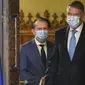 Calon kuat Perdana Menteri Romania Florin Citu (kiri) berjalan berdampingan dengan Presiden Romania Klaus Iohannis sebelum pengumuman pencalonannya di Buchares, Romania, Selasa, 22 Desember 2020 (AP)