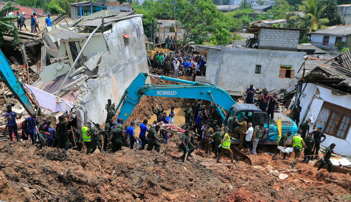 Tentara Sri Lanka menggunakan alat berat untuk menyelamatkan para korban yang terperangkap gunungan sampah di Meetotamulla, dekat ibukota Kolombo, Minggu (16/4). Sedikitnya 23 orang tewas dan enam orang dilaporkan hilang. (AP Photo/Eranga Jayawardena)