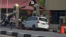 Petugas kepolisian mengamankan mobil yang digunakan terduga teroris setelah serangan di luar markas polisi di Pekanbaru, Riau (16/5). Dalam serangan tersebut satu perwira tewas dan dua lainnya terluka. (AFP Photo/Dedy Sutisna)