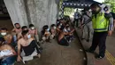 Petugas kepolisian mengamankan sejumlah orang yang diduga akan melakukan unjuk rasa di Kawasan Senayan, Jakarta, Kamis (8/10/2020). Mereka diduga hendak unjuk rasa menolak Undang-Undang Omnibuslaw Cipta Kerja di Gedung DPR. (merdeka.com/Imam Buhori)