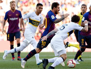 Penyerang Barcelona, Lionel Messi menggiring bola dari kejaran pemain Boca Juniors selama pertandingan Piala Joan Gamper di stadion Camp Nou, Spanyol (15/8). Barcelona menang telak 3-0 atas Boca Juniors. (AP Photo/Manu Fernandez)