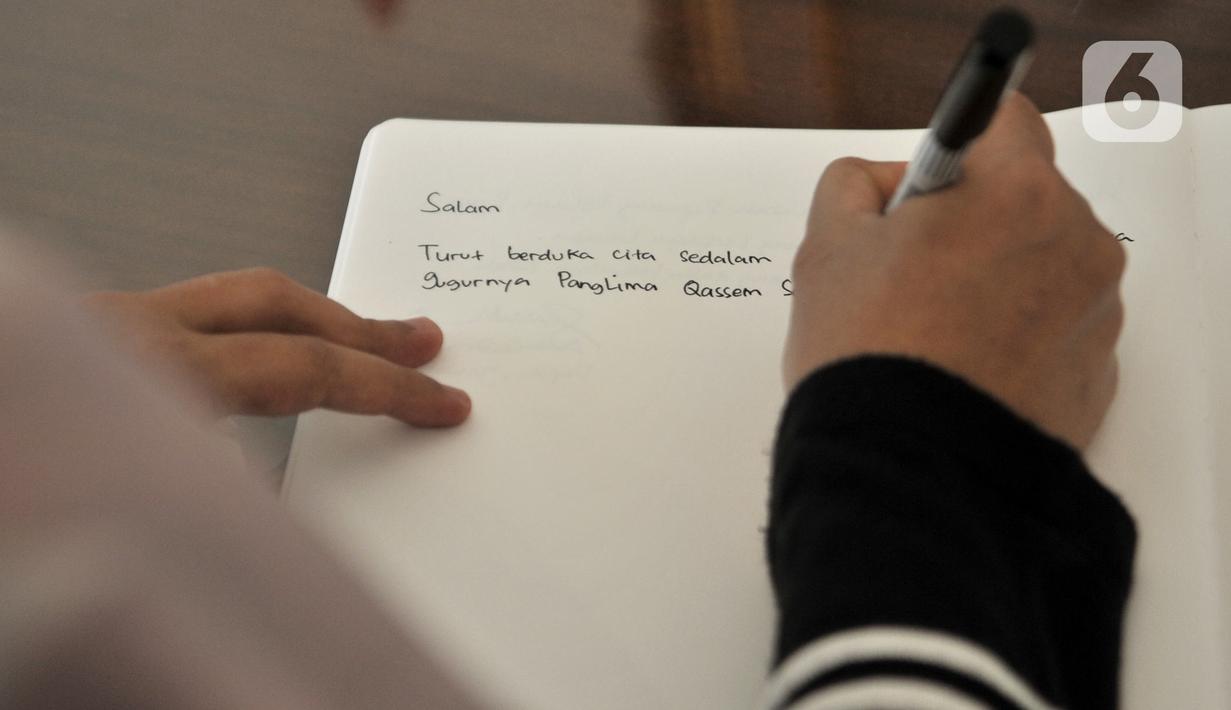 Warga menuliskan memo belasungkawa atas wafatnya Panglima Garda Revolusi Iran Jenderal Qasem Soleimani di Kedutaan Besar Iran, Jakarta, Selasa (7/1/2020). (merdeka.com/Iqbal S. Nugroho)