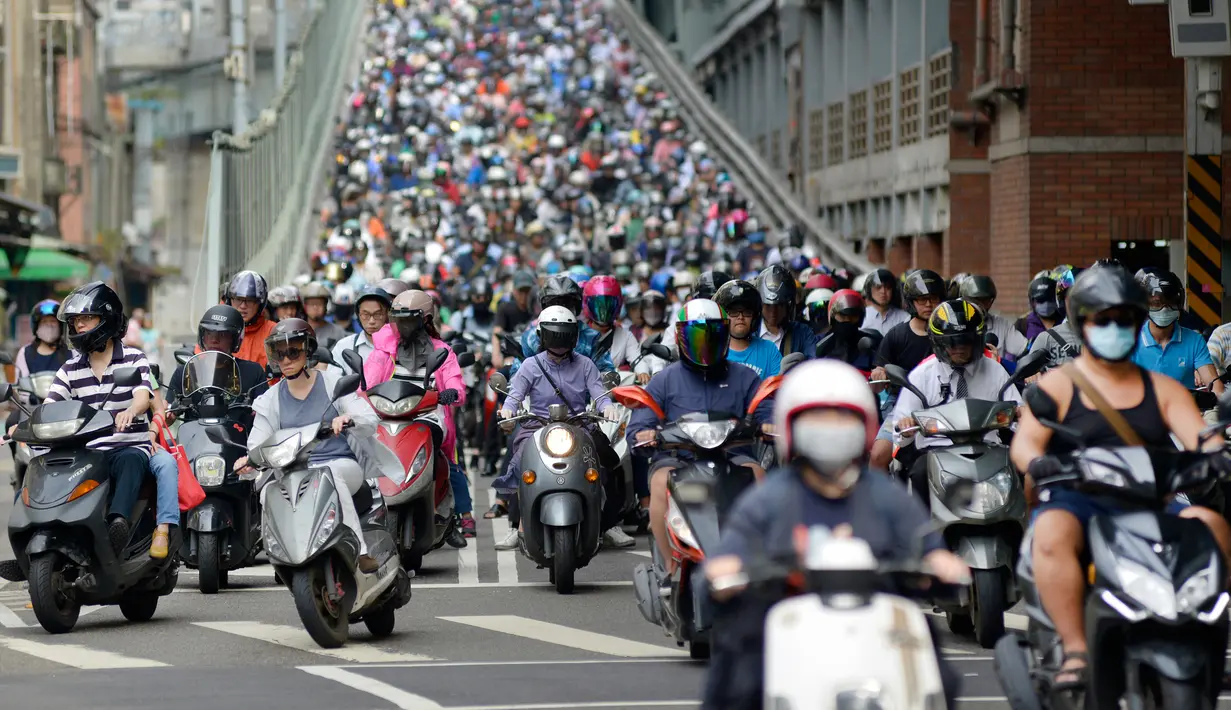 Pengendara sepeda motor melintasi Jembatan Taipei pada jam sibuk pagi hari, China (21/5). Sebelumnya telah beredar sebuah video mengejutkan mengenai kondisi sebuah jalan yang dipenuhi oleh antrean motor. (AFP Photo/Chris Stowers)