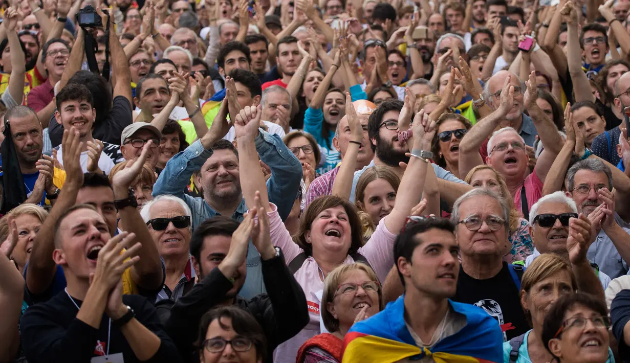Orang-orang merayakan ketika ketika Parlemen Catalonia mendeklarasikan kemerdekaan dari Spanyol di luar gedung parlemen di Barcelona, Jumat (27/10). Sejumlah pendukung kemerdekaan, turun ke jalan dan meneriakkan 'Liberty'. (AP/Emilio Morenatti)