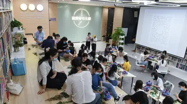 Orang-orang menghadiri kelas merangkai bunga di "Youth Channel" di Shenzhen, China (2/9/2020). Youth Channel adalah pusat komunitas yang menyediakan kuliah dan kelas budaya, seperti kursus ukulele dan keterampilan merangkai bunga bagi kaum muda sepulang bekerja. (Xinhua/Mao Siqian)