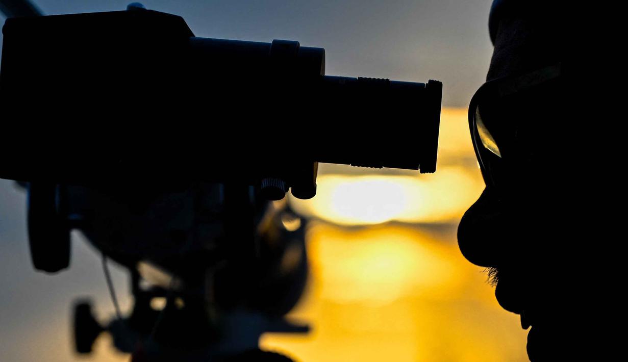 Jika hilal terlihat, besoknya masuk bulan baru. Jika tidak, bulan digenapkan 30 hari (istikmal). Tampak dalam foto, seorang pria mengamati bulan, menjelang Idul Fitri sekaligus menandai berakhirnya bulan suci Ramadan1447 Hijriah melalui teleskop di kantor observatorium, pantai Lhoknga, Aceh pada Kamis 19 Maret 2026. (CHAIDEER MAHYUDDIN/AFP)