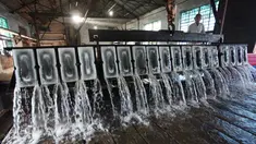 Seorang pekerja membuat es balok di sebuah pabrik di Yangzhou di provinsi Jiangsu timur China (8/7). (AFP Photo/China Out)