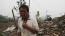Seorang pria berdiri di depan puing bangunan rumahnya akibat tornado menyapu wilayah Yancheng, Provinsi Jiangsu, Tiongkok, Kamis (23/6). Cuaca ekstrim termasuk hujan es, hujan lebat, dan angin puting beliung itu menewaskan sedikitnya 51 orang. (STR/AFP)