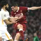 Pemain Liverpool, James Milner menyundul bola dibayangi pemain AS Roma pada laga leg pertama semifinal Liga Champions 2017-2018 di Anfield, Selasa (24/4). Liverpool mengalahkan AS Roma di kandang sendiri dengan skor 5-2.  (Filippo MONTEFORTE/AFP)