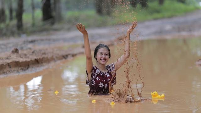 Wanita yang sedang berfoto di lumpur