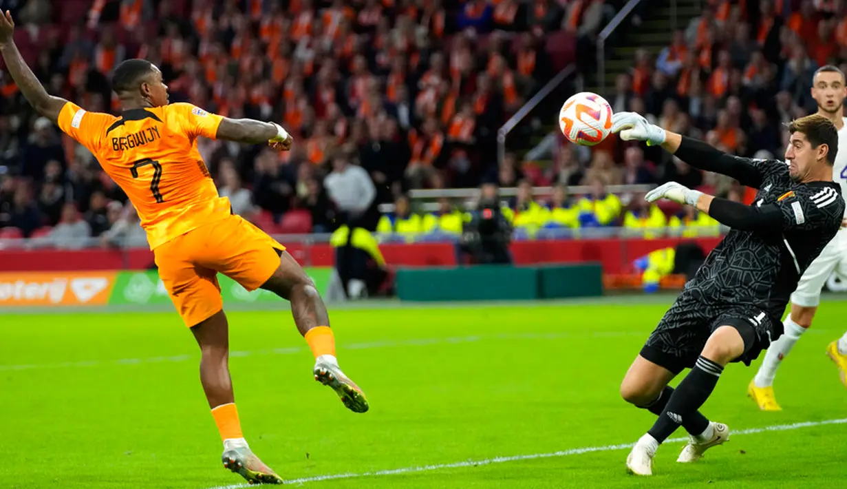 Penjaga gawang Belgia Thibaut Curtois (kanan) melakukan penyelamatan saat berhadapan dengan pemain Belanda Steven Bergwijn pada pertandingan sepak bola UEFA Nations League di Johan Cruyff ArenA, Amsterdam, Belanda, 25 September 2022. Belanda menang 1-0. (AP Photo/Peter Dejong)