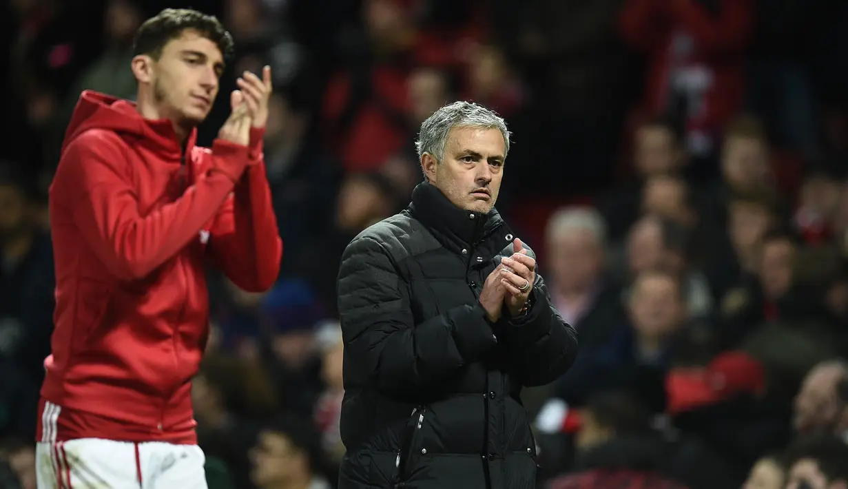Pelatih Manchester United, Jose Mourinho, bersama Matteo Darmian menyapa suporter usai melawan Liverpool. Hasil seri melawan Liverpool menghentikan sembilan kemenangan beruntun dari Setan Merah. (AFP/Oli Scarff)
