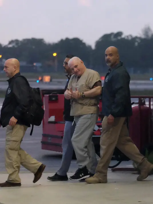 Mantan presiden Panama, Ricardo Martinelli dikawal Marshals AS saat diekstradisi dari Bandara Opa Locka, dekat Miami, Florida, AS, Senin (11/6). Martinelli ditangkap oleh otoritas AS pada Juni 2017 atas permintaan Panama. (Gaston De Cardenas/AFP)