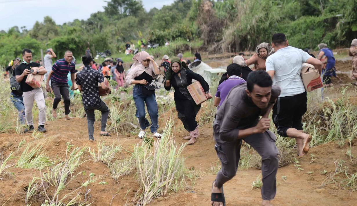 Distribusi logistik melalui jalur udara akan terus dilakukan dengan menyesuaikan kebutuhan para warga terdampak. Tampak dalam foto, para penyintas banjir bergegas menerima bantuan yang didistribusikan oleh helikopter TNI AU di Aceh Tengah, Sabtu 6 Desember 2025. (AP Photo/Reza Saifullah)