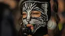 Seorang wanita bertopeng memainkan seruling saat pawai memperingati Hari Anti Kekerasan Terhadap Perempuan di Santiago, Chile, 25 November 2021. Majelis Umum Perserikatan Bangsa-Bangsa (PBB) mengangkat 25 November menjadi Hari Anti Kekerasan Terhadap Perempuan. (AP Photo/Esteban Felix)