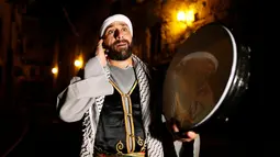 Michel Ayoub, seorang Kristen Arab-Israel, ketika membangunkan kaum muslim untuk melaksanakan sahur di Arce, Israel, Senin (20/6). Michel Ayoub sudah bertahun-tahun membangunkan sahur kaum muslim di sekitarnya selama Ramadan. (REUTERS/Ammar Awad)
