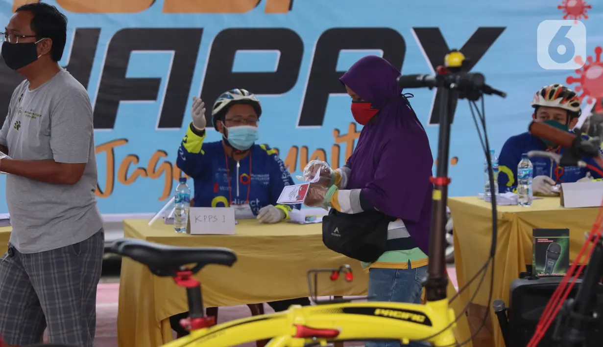 Warga menggunakan hak pilihnya dalam Pilkada 2020 di TPS 23 Pondok Jagung Timur, Tangerang Selatan, Rabu (9/12/2020). TPS Pilkada Tangerang Selatan (Tangsel) itu menggunakan tema hobi dimana petugasnya mengenakan pakaian untuk bersepeda. (Liputan6.com/Angga Yuniar)