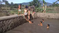 Di tempat warga mengantre air kotor itu, anak-anak desa setempat malah asyik berenang di kolam ikan. (Liputan6.com/Jayadi Supriadin)