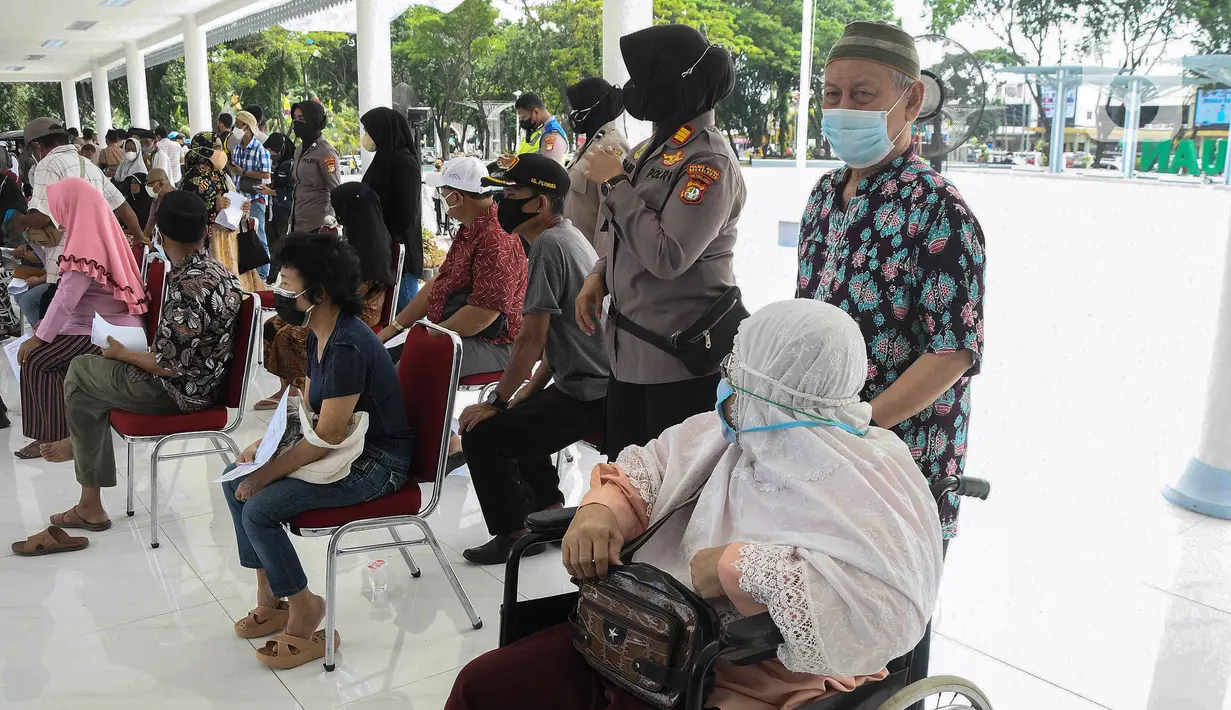 Warga lanjut usia (lansia) menunggu untuk menerima suntikan vaksin Sinovac dari petugas medis di Alun-Alun Bekasi, Jawa Barat, Rabu (23/2/2022). Sebanyak 600 dosis vaksin Sinovac disiapkan pemerintah setempat untuk warga lansia guna mencegah penyebaran COVID-19. (Liputan6.com/Herman Zakharia)