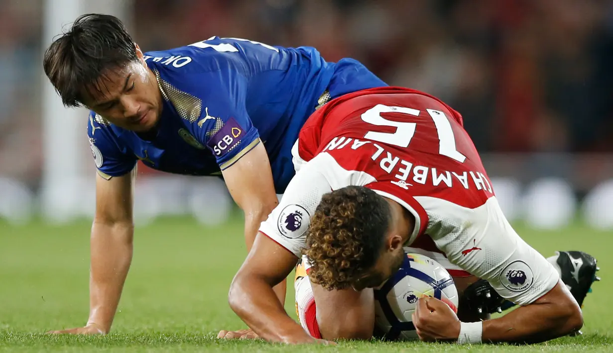 Penyerang Leicester City Shinji Okazaki berebut bola dengan pemain Arsenal Alex Oxlade-Chamberlain saat pertadingan Liga Inggris di  Stadion Emirates, London (11/8). (AP Photo/Alastair Grant)