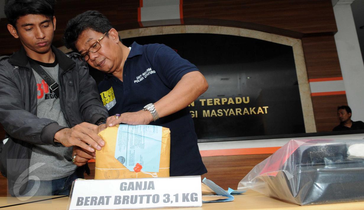 Petugas saat memeriksa barang bukti Narkoba di  Polres Jakarta Timur, Sabtu (6/2). Sebanyak 3,1 kg Ganja dan 1/4 kg sabu dan 419 butir pil ekstasy diamankan petugas Polres Jakarta Timur. (Liputan6.com/Helmi Afandi)
