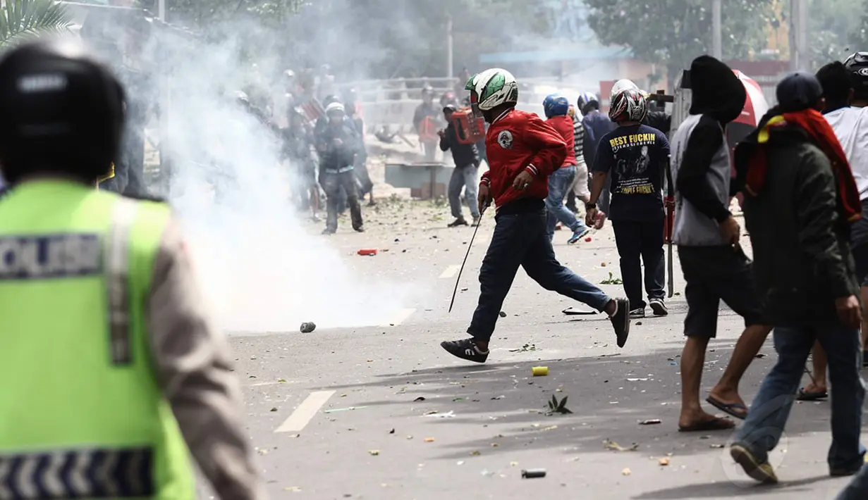 Puluhan aparat kepolisian berusaha melerai aksi tawuran di kawasan Manggarai, Jakarta, Minggu (30/11/2014). (Liputan6.com/Faizal Fanani)
