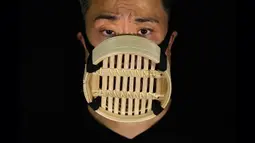 Edmond Kok, aktor dan desainer kostum teater Hong Kong, mengenakan masker wajah yang terbuat dari kukusan bambu China di Hong Kong pada 6 Agustus 2020. Sepanjang pandemi, Edmond telah membuat lebih dari 170 masker yang terinspirasi oleh pandemi dan masalah politik Hong Kong. (AP Photo/Vincent Yu)