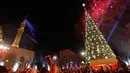 Warga mengambil gambar pohon natal yang sedang dihiasi percikan kembang api di dekat Masjid Mohammad al-Amin di Beirut, Lebanon (10/12). Pohon natal ini dipajang bersebelahan dengan Masjid Mohammad al-Amin. (AFP Photo/Stringer)