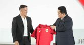 Ketua Persatuan Sepak Bola Seluruh Indonesia (PSSI), Erick Thohir (kanan) menyerahkan jersey tim kepada pelatih kepala tim nasional Indonesia yang baru ditunjuk, John Herdman, saat konferensi pers di Jakarta, Selasa 13 Januari 2026. Persatuan Sepak Bola Seluruh Indonesia (PSSI) resmi memperkenalkan John Herdman sebagai pelatih baru Timnas Indonesia. (AP Photo/Achmad Ibrahim)