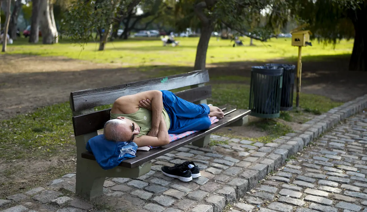 Seorang pria beristirahat di bangku taman di Buenos Aires, Argentina, Rabu, 2 Agustus 2023. Ibu kota Argentina memecahkan rekor awal Agustus terpanas dalam 117 tahun terakhir. (AP Photo/Natacha Pisarenko)