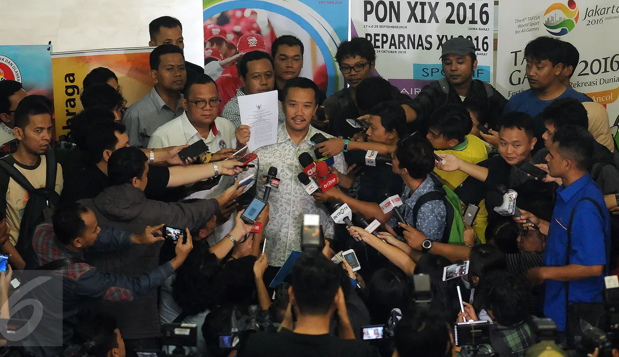 Menpora Imam Nahrawi (tengah) menunjukkan SK Pencabutan Keputusan Menpora No 01307 tahun 2015 tentang Sanksi PSSI di Gedung Kemenpora, Jakarta, Rabu (11/5/2016). Pencabutan ini tindak lanjut putusan MA dan amanat FIFA. (Liputan6.com/Helmi Fithriansyah)