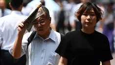 Seorang pria melindungi dirinya dari sinar matahari dengan sebuah koran saat gelombang panas di Tokyo, Jepang (1/7/2019). Cuaca panas ekstrem yang melanda Jepang telah menewaskan puluhan orang tewas dan menyebabkan ribuan orang masuk rumah sakit dengan gejala dehidrasi. (AFP Photo/Charly Triballeau)