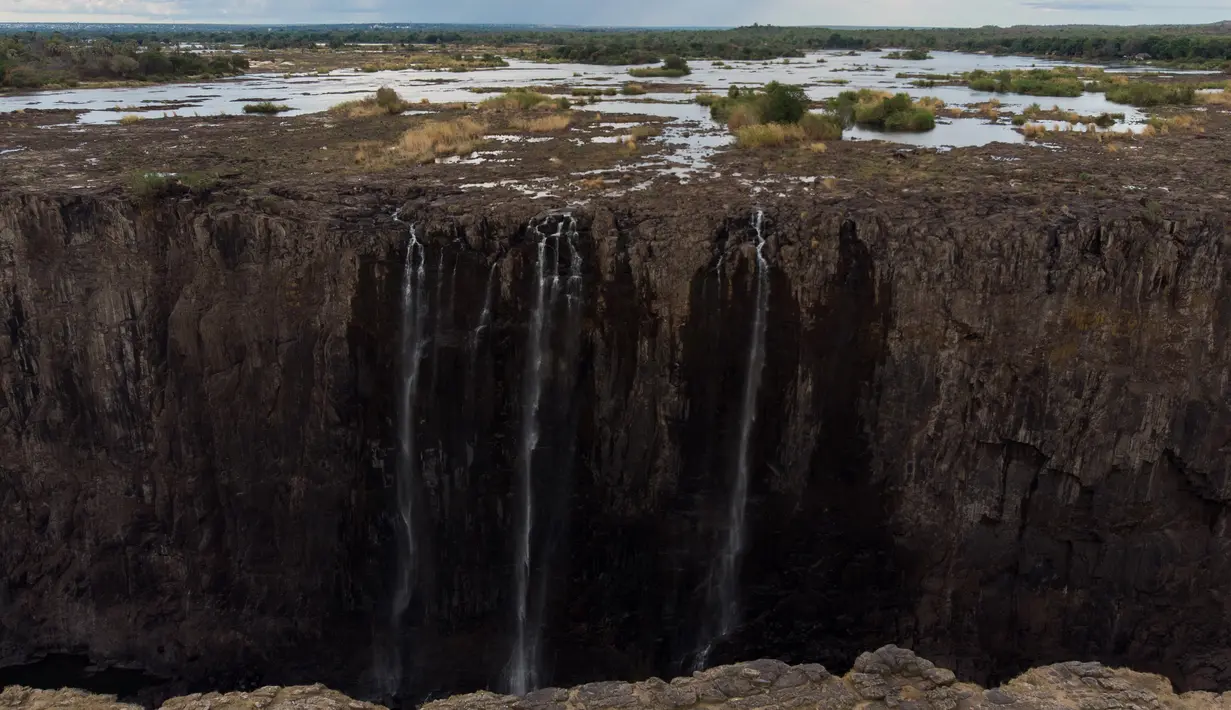 Pemandangan air terjun Victoria, salah satu air terjun terbesar di dunia, di Zimbabwe pada 10 Desember 2019. Musim kemarau yang terjadi membuat air terjun yang masuk dalam Situs Warisan Dunia UNESCO ini mengalami kekeringan terparah selama beberapa dekade lalu. (ZINYANGE AUNTONY/AFP)