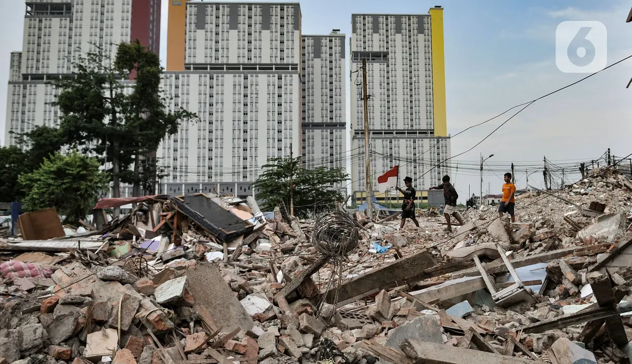 Anak-anak melintas di atas puing permukiman yang digusur di Delta Serdang, Kemayoran, Jakarta, Rabu (4/11/2020). Sebanyak 61 rumah yang dihuni sekitar 200 warga di RW 07 Delta Serdang rata dengan tanah usai digusur untuk proyek 6 Ruas Tol Dalam Kota rute Semanan-Sunter. (merdeka.com/Iqbal S Nugroho)