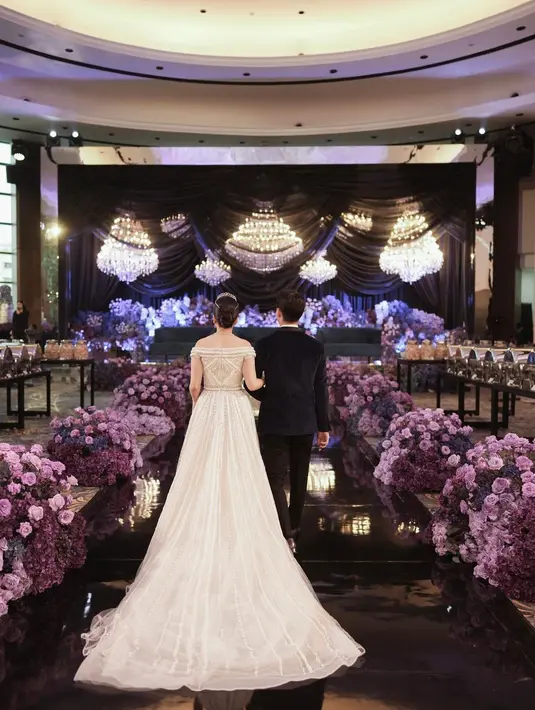 Gaun tersebut tampak semakin mewah dengan train yang menjuntai hingga ke lantai dan detail mutiara yang menghiasi keseluruhan gaun. [Foto: IG/morden.co/sincerelove.photo].